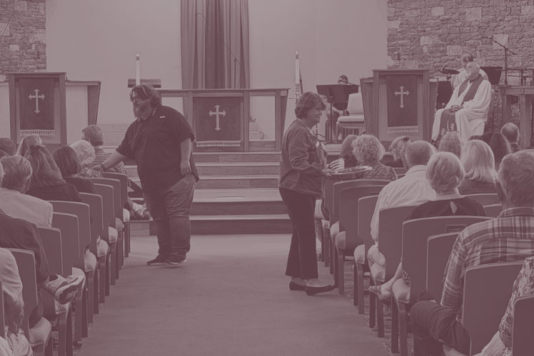 Ushers pass the offertory plate through the pews during worship at Christ UMC Franklin.